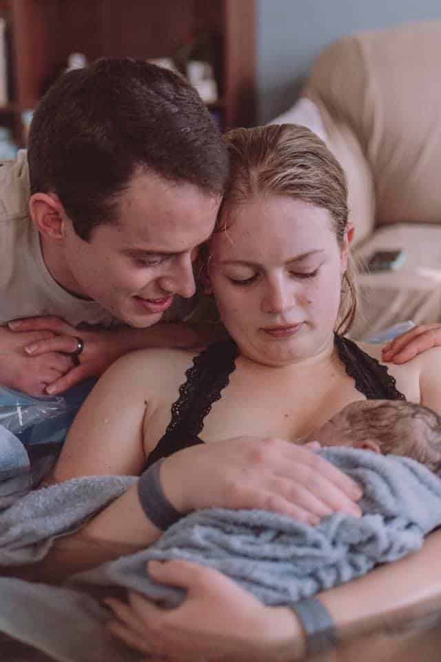 Hypno-mom Amelia and partner looking down on newborn baby.