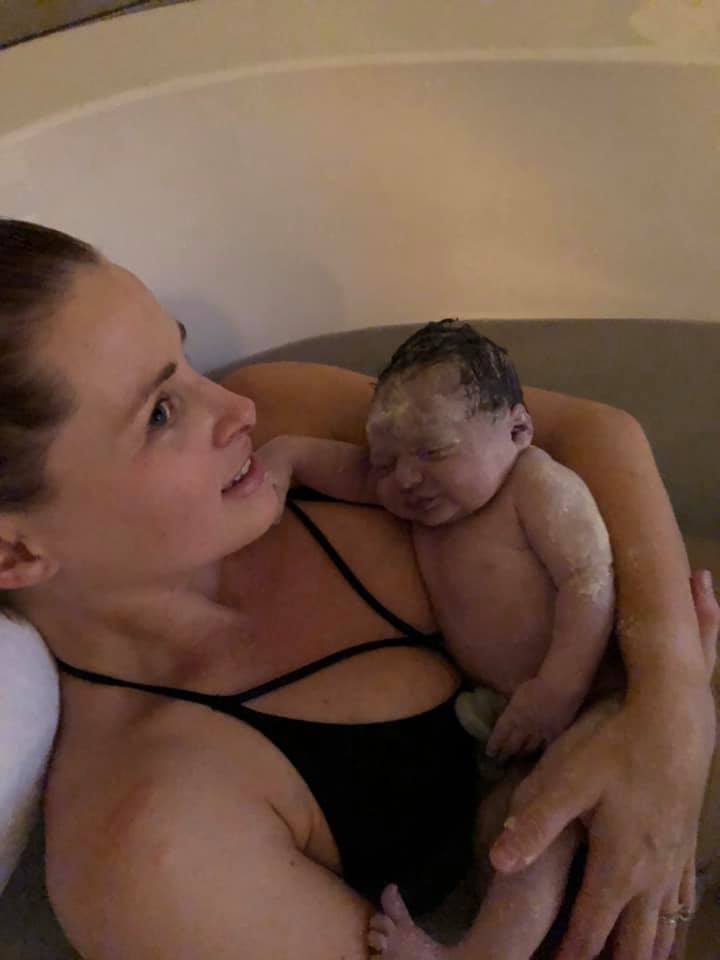 Hypno-mom laying in tub holding newborn baby