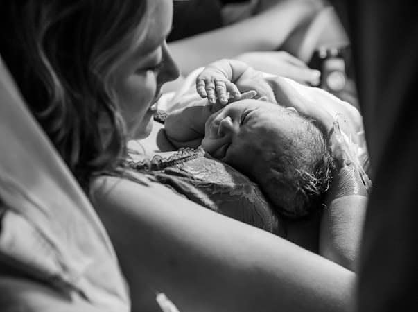 New parent gazing down and newborn baby