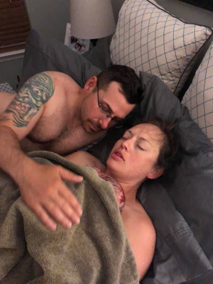 Hypno-mom Anna just after birth in bed with her partner and newborn baby.