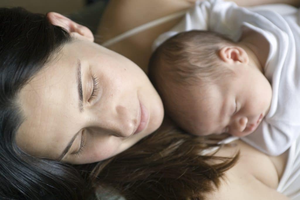 mom and newborn baby lying down together
