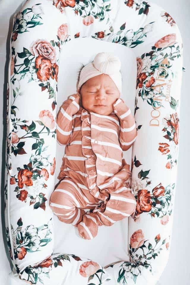 Hypno-mom Carrie's newborn baby in a flowered baby bed.