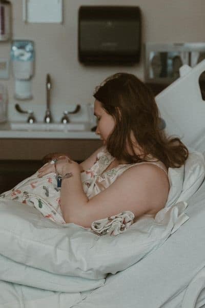 new mom holding newborn in hospital bed