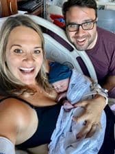 Hypno-mom and partner smiling and holding their newborn baby.