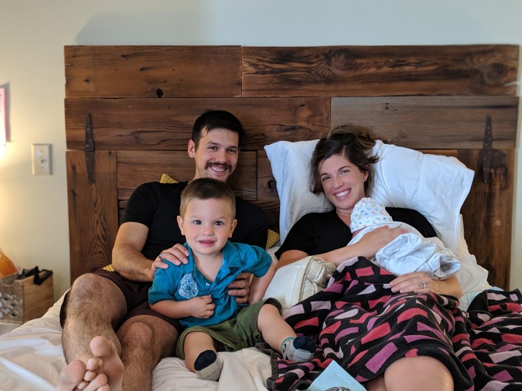 Hypno-mom Danae in bed with birth partner, toddler son and newborn.