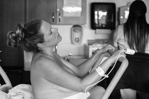 Black and white photo of hypno-mom pushing while holding the squat bar