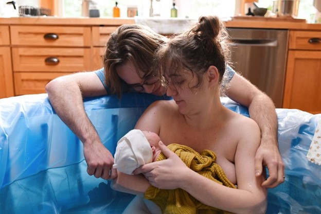 New parents gazing down at newborn baby