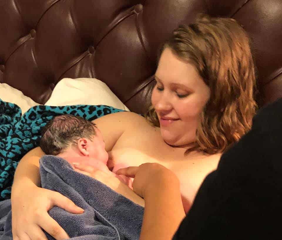 Hypno-mom McKenzie skin to skin and nursing her newborn in bed.