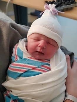 newborn baby swaddled with a hat on.