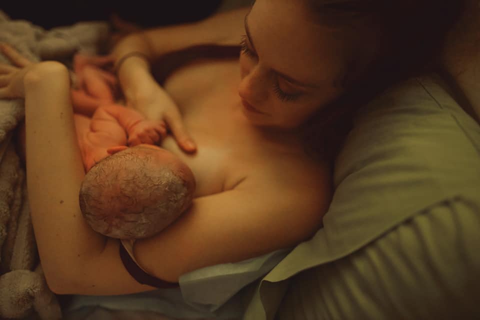 Hypno mom laying in bed and nursing newborn