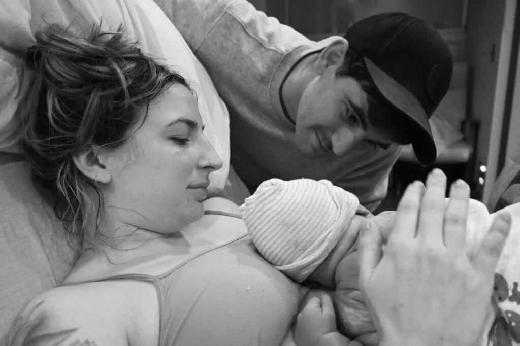 new parent smiling at newborn baby